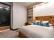 Comfortable bedroom featuring built-in shelving, a desk area, and a cozy bed with patterned throw pillows at 9 Sedgwick Dr, Englewood, CO 80113