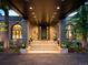 This covered entryway features concrete steps leading to double doors, flanked by large windows and potted plants at 9 Sedgwick Dr, Englewood, CO 80113