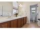 Bathroom featuring dual sinks, wood cabinets, decorative lighting, and tiled floor at 5605 Killen Ave, Castle Rock, CO 80104