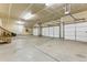 Three car garage with concrete flooring, white doors, and ample storage space at 5605 Killen Ave, Castle Rock, CO 80104
