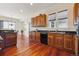 Open kitchen with wood cabinetry, stainless appliances, dark countertops, and hardwood floors at 5605 Killen Ave, Castle Rock, CO 80104