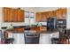 A kitchen features dark countertops, wooden cabinets, and a breakfast bar with seating at 5605 Killen Ave, Castle Rock, CO 80104