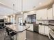 Modern kitchen with white cabinets, a large island, and stainless steel appliances at 19085 Robins Dr, Denver, CO 80249