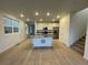 Bright, open-concept kitchen with island, stainless steel appliances and hardwood flooring at 6739 Juniper Dr, Thornton, CO 80602