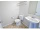 Small bathroom featuring a pedestal sink, toilet, and tiled floor at 451 S Reed St, Lakewood, CO 80226