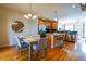 Open dining area and kitchen with stainless steel appliances, island with seating, and hardwood floors at 451 S Reed St, Lakewood, CO 80226