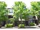 Inviting townhome exterior with brick accents, lush greenery, and mature shade trees at 451 S Reed St, Lakewood, CO 80226