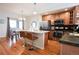 Open kitchen and dining area with stainless steel appliances, island with seating, and hardwood floors at 451 S Reed St, Lakewood, CO 80226