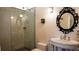 Tiled bathroom featuring a glass-enclosed shower, toilet, and pedestal sink with ornate mirror at 421 Dexter St, Denver, CO 80220