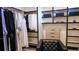 Custom walk-in closet with organized storage, hanging space, and a stylish chair at 421 Dexter St, Denver, CO 80220