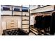 Well-organized closet with open shelving, hanging rods, and a tufted chair at 421 Dexter St, Denver, CO 80220
