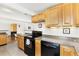 Efficient kitchen featuring oak cabinets, tile flooring, and an open view of the living room at 2600 Valley View Dr, Denver, CO 80221