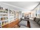 Spacious living room with hardwood floors, bookshelves, and comfortable sectional sofa at 4844 E 110Th Pl, Thornton, CO 80233