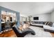 Open-concept living room with hardwood floors, leather sectional, and view of kitchen at 4844 E 110Th Pl, Thornton, CO 80233