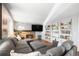 Cozy living room with brick fireplace, large sectional sofa, and built-in bookshelves at 4844 E 110Th Pl, Thornton, CO 80233