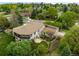 Aerial view of a large home with mature landscaping, a stone patio, and a circular driveway at 1 Rangeview Dr, Wheat Ridge, CO 80215