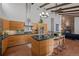 Modern kitchen featuring wood cabinets, stainless steel appliances, a center island with seating, and hardwood floors at 1 Rangeview Dr, Wheat Ridge, CO 80215