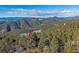 Scenic mountain views surround this beautiful wooded lot with blue sky and snow-capped mountain peaks at 12933 Upper Ridge Rd, Conifer, CO 80433