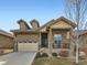 Charming home featuring a two-car garage, stone accents, dormer windows, and covered porch at 4420 White Rock Dr, Broomfield, CO 80023