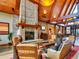 Inviting lounge with a stone fireplace, comfortable seating, and vaulted wood beam ceilings at 4420 White Rock Dr, Broomfield, CO 80023