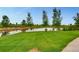 A picturesque pond surrounded by lush green grass and mature trees, creating a serene view at 4420 White Rock Dr, Broomfield, CO 80023