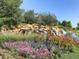 Serene water feature with cascading waterfalls, colorful flowers, and lush landscaping at 4420 White Rock Dr, Broomfield, CO 80023