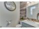 Charming bathroom features a decorative mirror, attractive light fixture, wood accent wall and a marble vanity top at 18079 E 108Th Pl, Commerce City, CO 80022