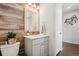 Charming half bathroom with wood accent wall, marble countertop, and decorative mirror at 18079 E 108Th Pl, Commerce City, CO 80022