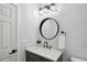 Stylish bathroom with a round mirror, modern vanity, and sleek black faucet at 18079 E 108Th Pl, Commerce City, CO 80022
