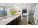Well-lit bathroom featuring a dual sink vanity, modern fixtures, and a glimpse into an adjacent bedroom at 18079 E 108Th Pl, Commerce City, CO 80022