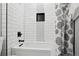 Bright bathroom featuring a shower tub with tile and a decorative black inset at 18079 E 108Th Pl, Commerce City, CO 80022
