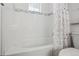 Bathroom featuring white tiled walls surrounding bathtub and shower with decorative shower curtain at 18079 E 108Th Pl, Commerce City, CO 80022