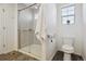 Bathroom showcasing glass shower with white tile surround, toilet and window at 18079 E 108Th Pl, Commerce City, CO 80022