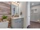 Charming bathroom features a decorative mirror, attractive light fixture, wood accent wall and a marble vanity top at 18079 E 108Th Pl, Commerce City, CO 80022