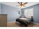Cozy bedroom with soft blue walls, modern decor, a ceiling fan, and hardwood floors at 18079 E 108Th Pl, Commerce City, CO 80022