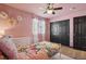 Inviting bedroom with warm pink walls, a ceiling fan, and a large window with sheer curtains at 18079 E 108Th Pl, Commerce City, CO 80022