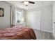 Bedroom featuring a ceiling fan, light-grey walls and brown wood-look floors and closet doors at 18079 E 108Th Pl, Commerce City, CO 80022