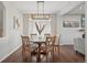 Bright dining room with hardwood floors, round table, modern lighting, and large window providing natural light at 18079 E 108Th Pl, Commerce City, CO 80022