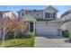 Inviting two-story home with a well-maintained lawn and a two-car garage with grey sidings at 18079 E 108Th Pl, Commerce City, CO 80022