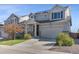 Inviting two-story home with a well-maintained lawn and a two-car garage with grey sidings at 18079 E 108Th Pl, Commerce City, CO 80022