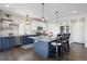 Spacious kitchen features stylish blue cabinets, granite countertops, stainless steel appliances and a large island at 18079 E 108Th Pl, Commerce City, CO 80022