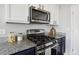 Kitchen showcases a stainless steel gas range and microwave with dark cabinets at 18079 E 108Th Pl, Commerce City, CO 80022