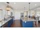 Open kitchen featuring a large island, granite countertops, stainless steel appliances, and stylish pendant lighting at 18079 E 108Th Pl, Commerce City, CO 80022