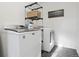 Functional laundry room with modern washer and dryer, plus a storage shelf at 18079 E 108Th Pl, Commerce City, CO 80022