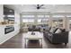 Bright living room featuring a modern fireplace, large windows, and a comfortable seating area at 18079 E 108Th Pl, Commerce City, CO 80022