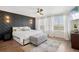 Stylish main bedroom with a wood accent wall, ceiling fan, and neutral color palette at 18079 E 108Th Pl, Commerce City, CO 80022