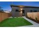 Modern home with a fenced backyard and a small lawn area with privacy fencing at 2450 S Cherokee St, Denver, CO 80223