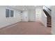 Finished basement featuring carpet, a window, and a staircase to the upper floors at 2450 S Cherokee St, Denver, CO 80223