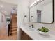 Modern bathroom vanity with sleek fixtures, a stylish mirror and a view to the open staircase at 2450 S Cherokee St, Denver, CO 80223