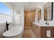 Modern bathroom with a soaking tub, double vanity, and glass shower at 2450 S Cherokee St, Denver, CO 80223